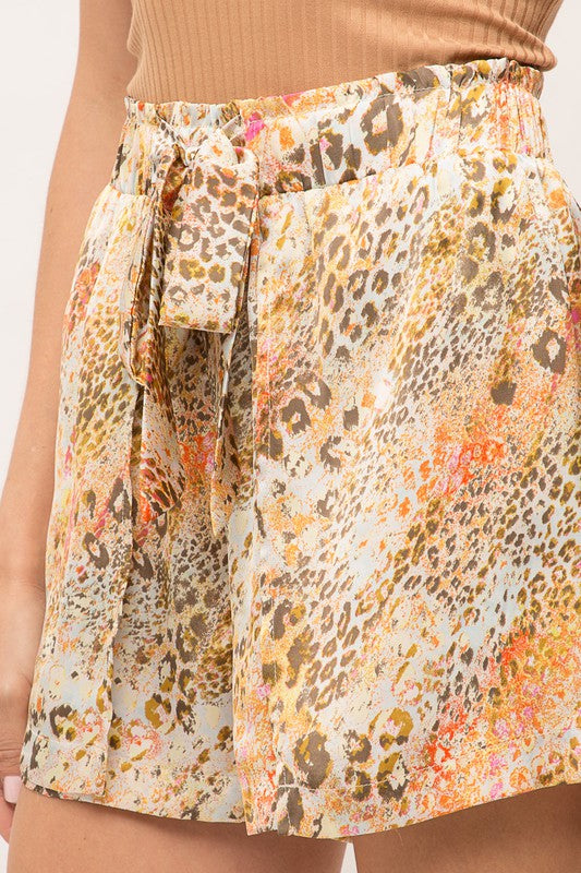 Multicolored patterned shorts with a belt on a neutral background