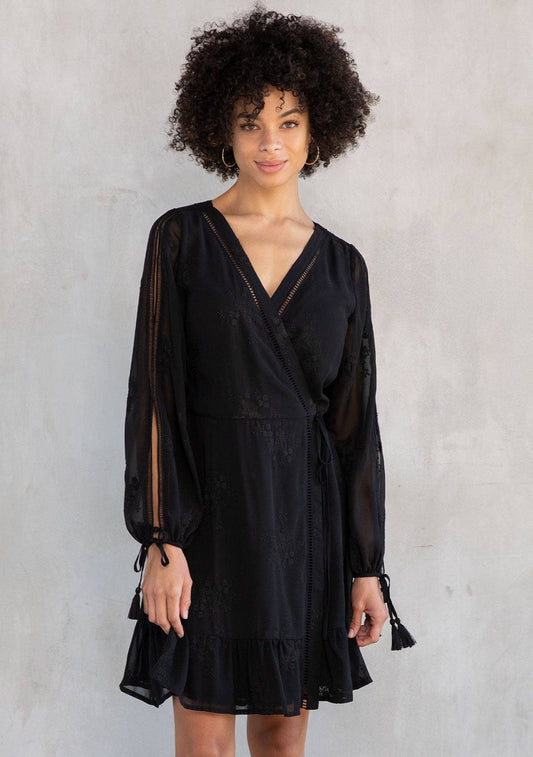 Woman wearing a black dress against a gray background