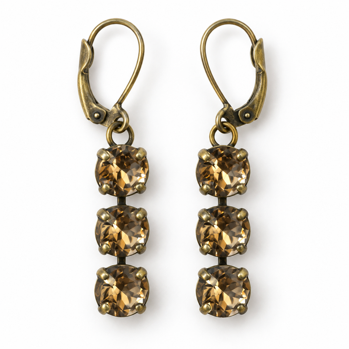 A pair of drop earrings with antique bronze leverback hooks and three faceted brownish-gold square crystals each, shown on a plain white background.