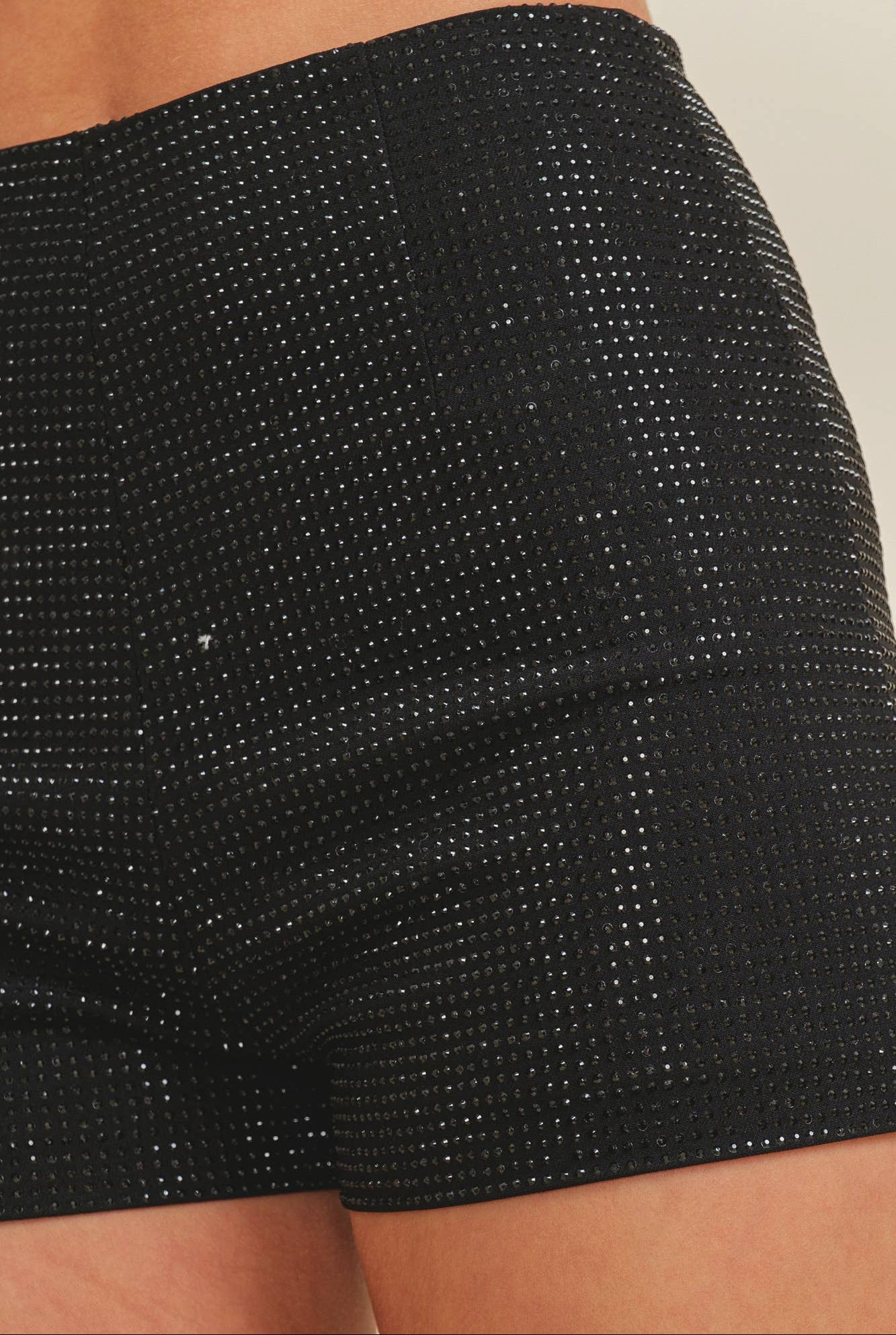 Close-up of black textured shorts on a neutral background