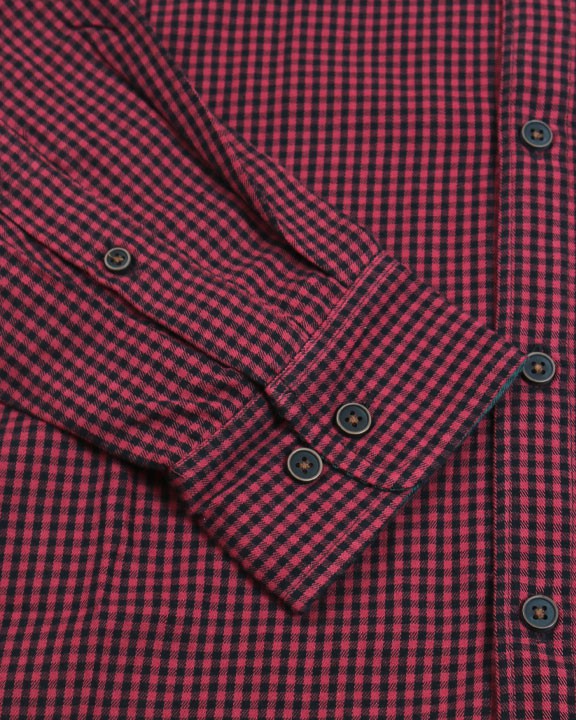 Close-up of a red and black checkered shirt with buttons.