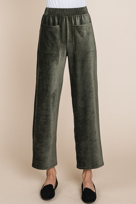 Green pants worn by a person on a beige background