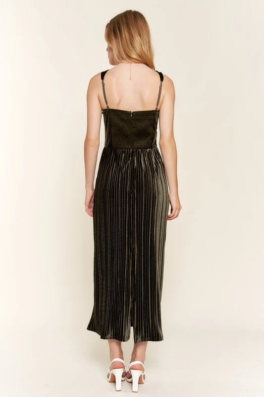 Woman wearing a olive pleated dress on a beige background