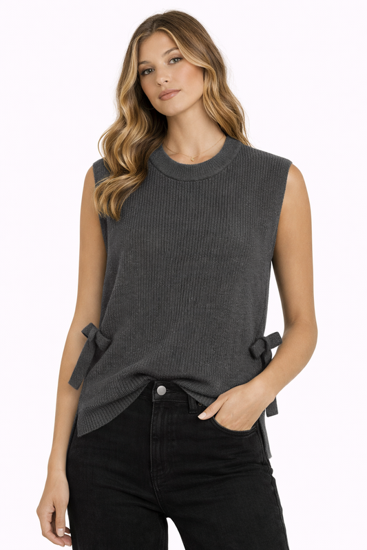 Woman wearing a gray sleeveless sweater with bow details on a white background