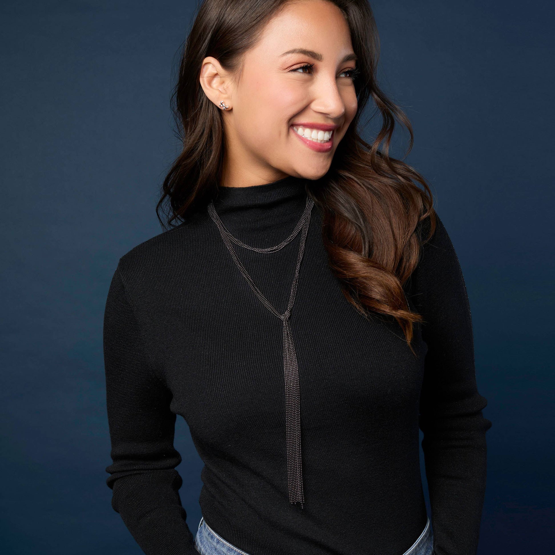 Woman wearing a black turtleneck with a blue background