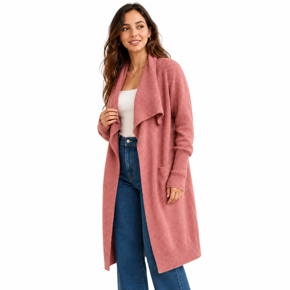 A woman modeling a long, dusty pink open-front knit cardigan over a white top and blue jeans, photographed against a solid white background.
