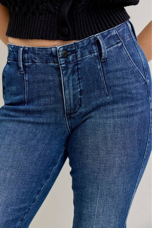 Blue jeans worn by a person on a plain background