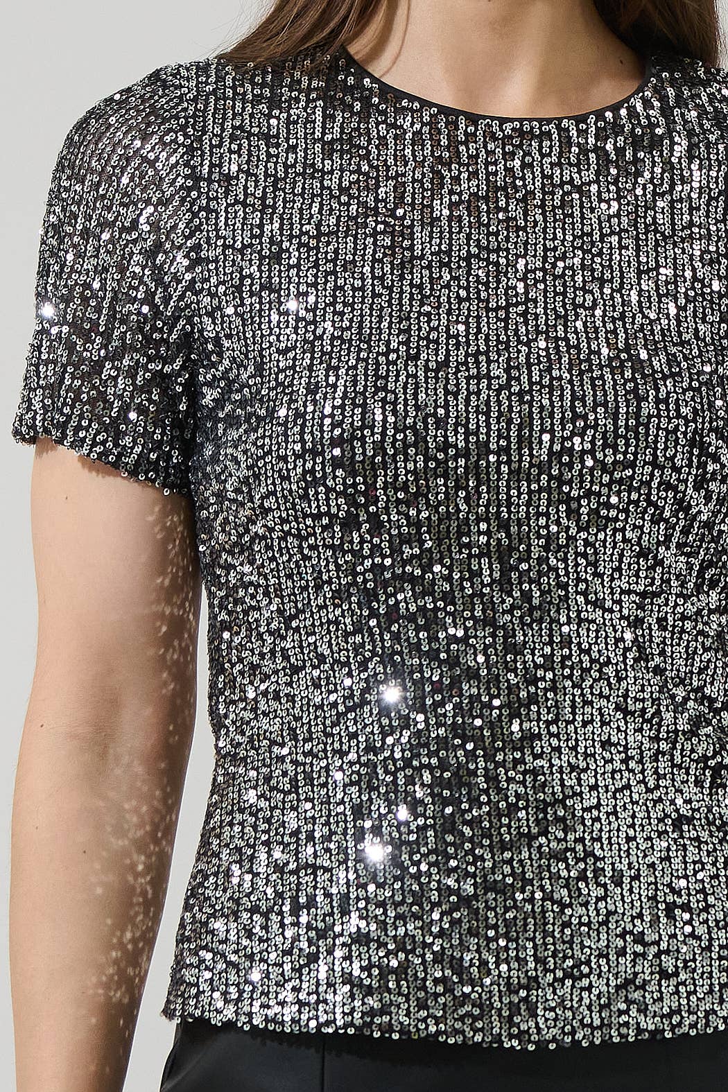 Close-up of a sequined black top with a blurred background