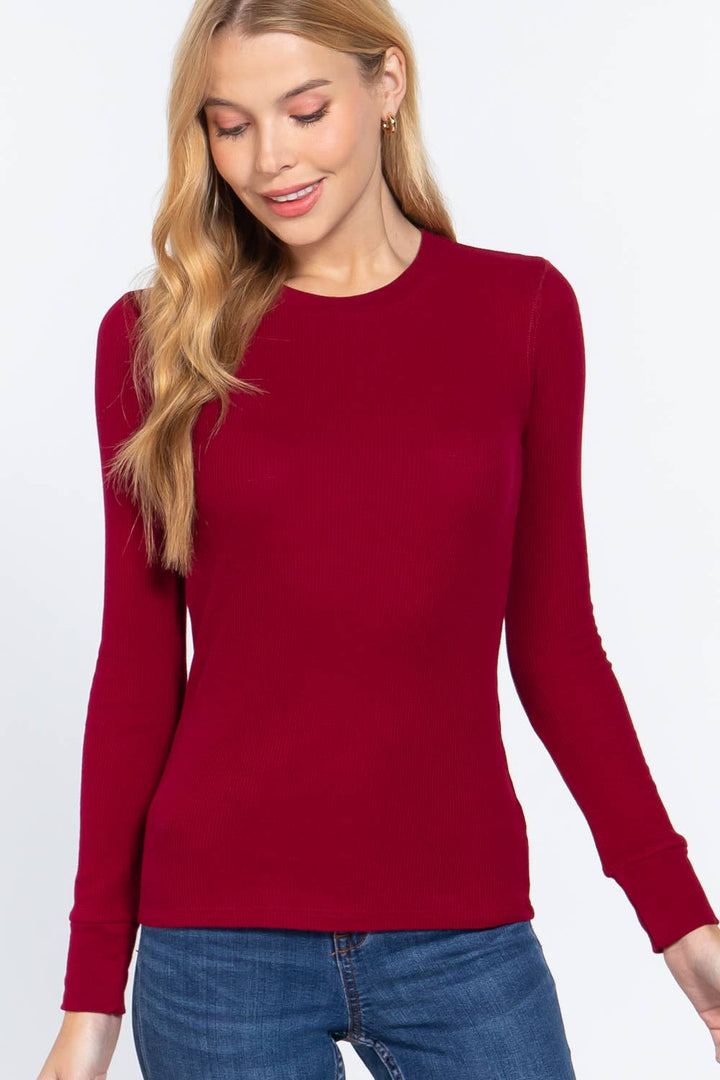Woman wearing a red thermal top blue jeans on a white background