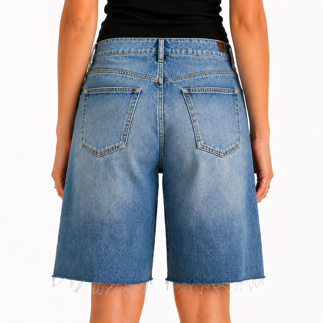 Blue denim shorts worn by a person on a white background