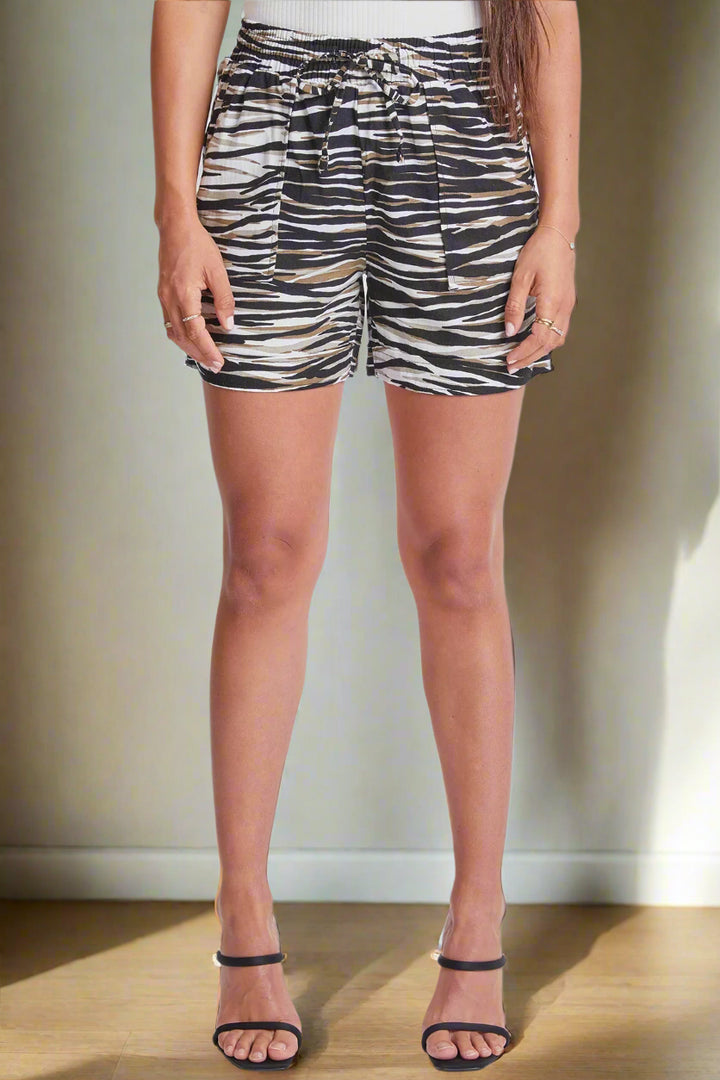 Person wearing zebra print shorts on a plain background