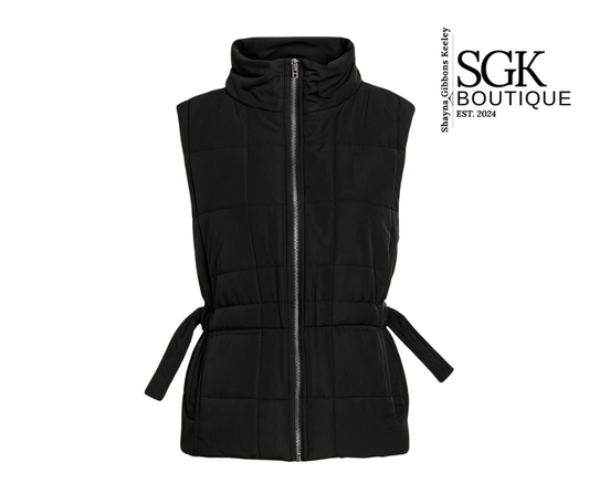 Black quilted vest with a belt on a white background, featuring the SGK Boutique logo.