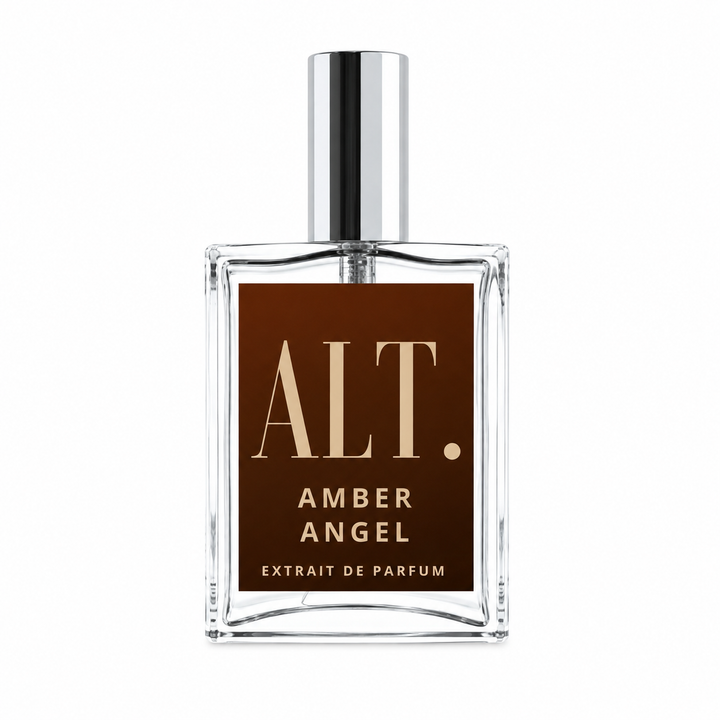 A clear glass perfume bottle with a reflective silver cap and a dark brown rectangular label. The label features the text &