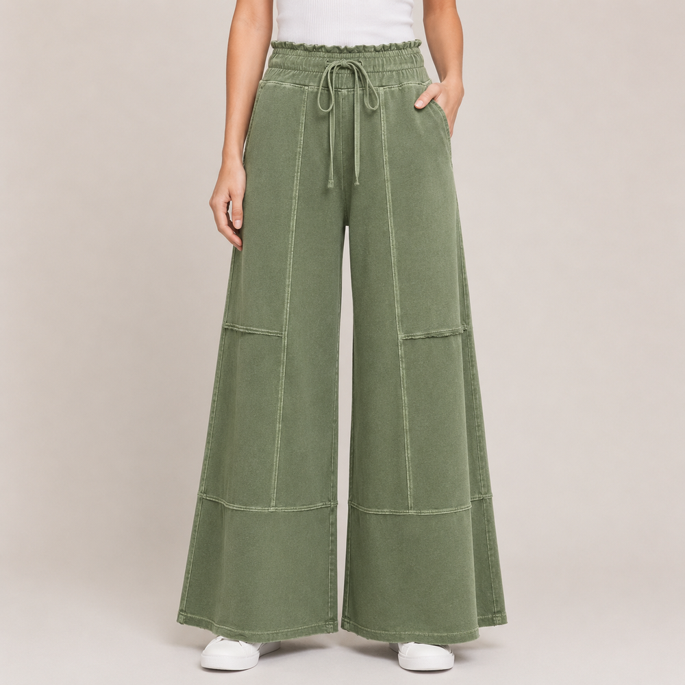 Green wide-leg pants worn by a person on a beige background