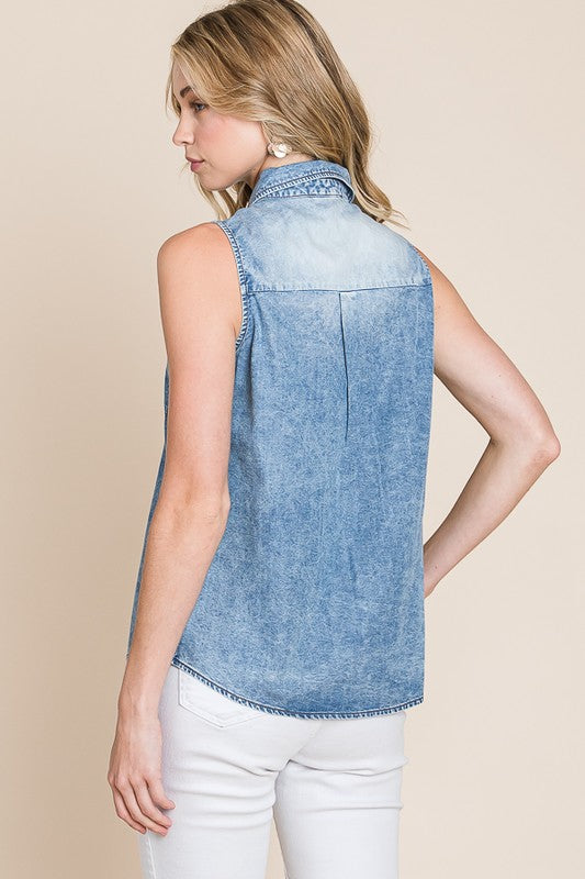 Woman wearing a sleeveless denim top against a beige background
