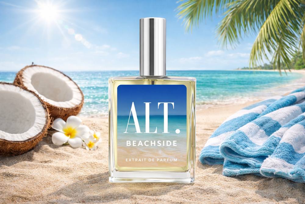 Perfume bottle labeled 'ALT Beachside' on a beach with coconuts and a towel.