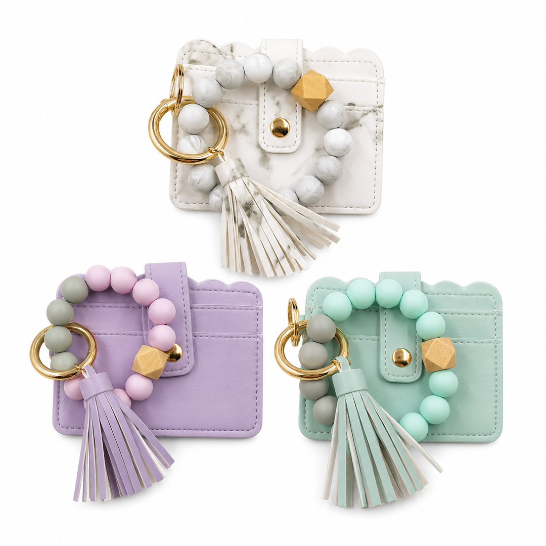Three colorful keychains with tassels on a white background