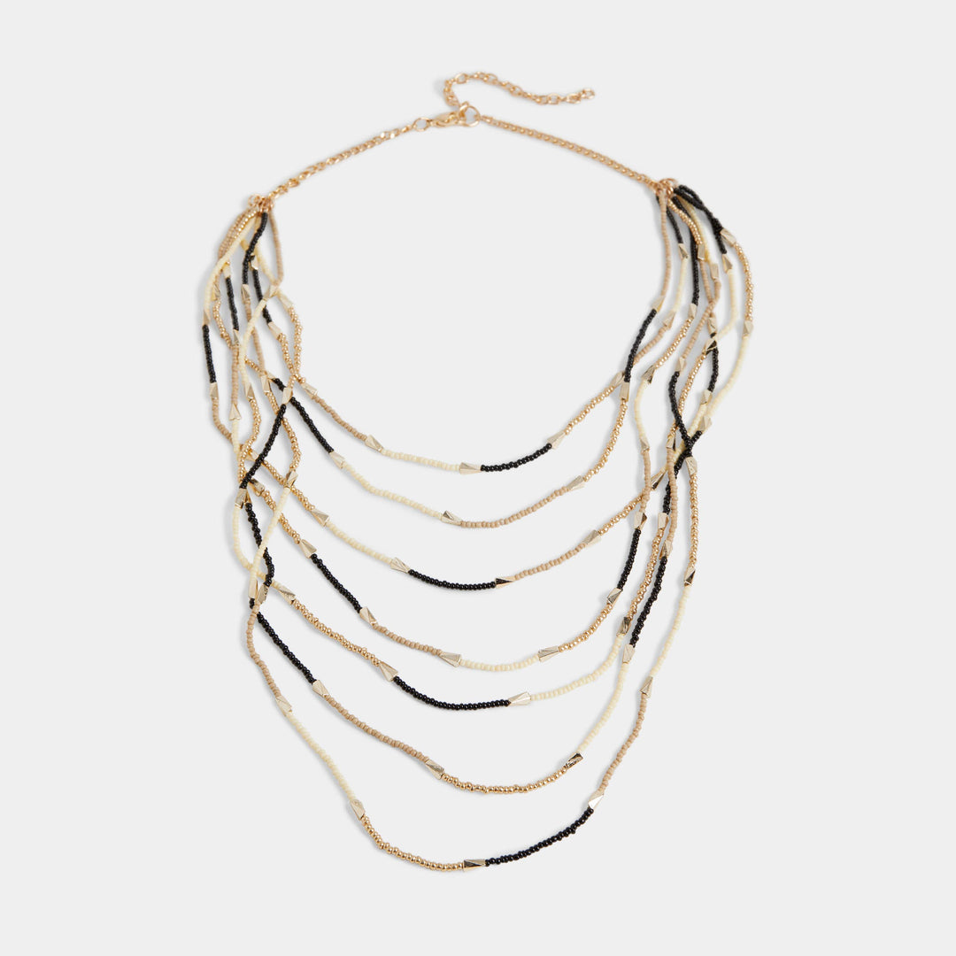 Layered necklace with gold and black strands on a white background