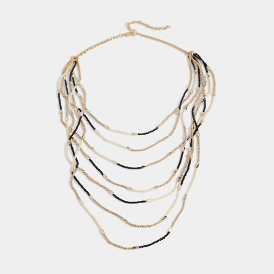 Layered necklace with gold and black strands on a white background