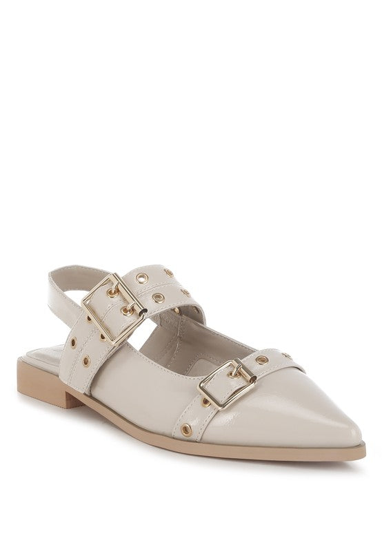 Beige flat shoe with gold buckles on a white background