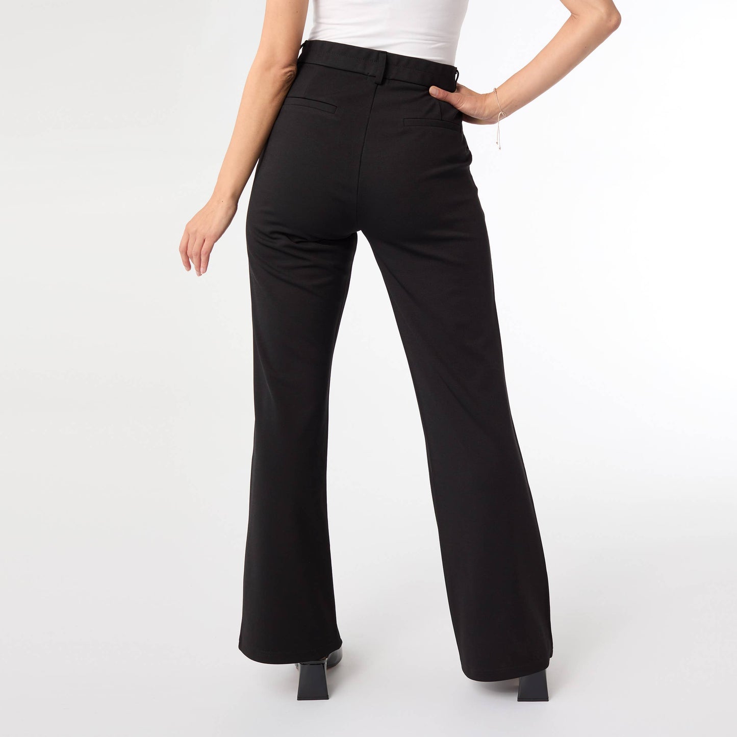 Black pants worn by a person on a white background