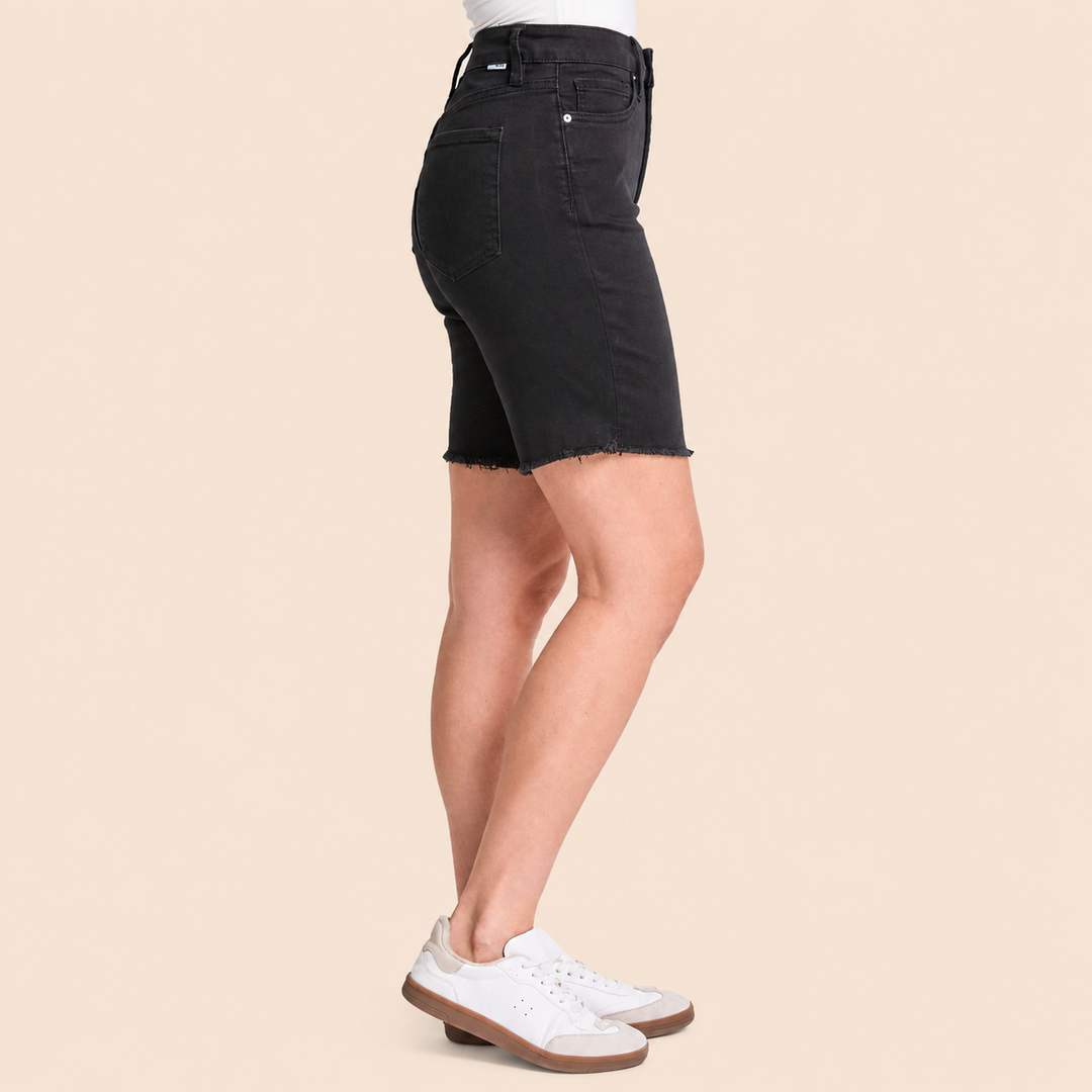 Black denim skirt worn by a person on a beige background