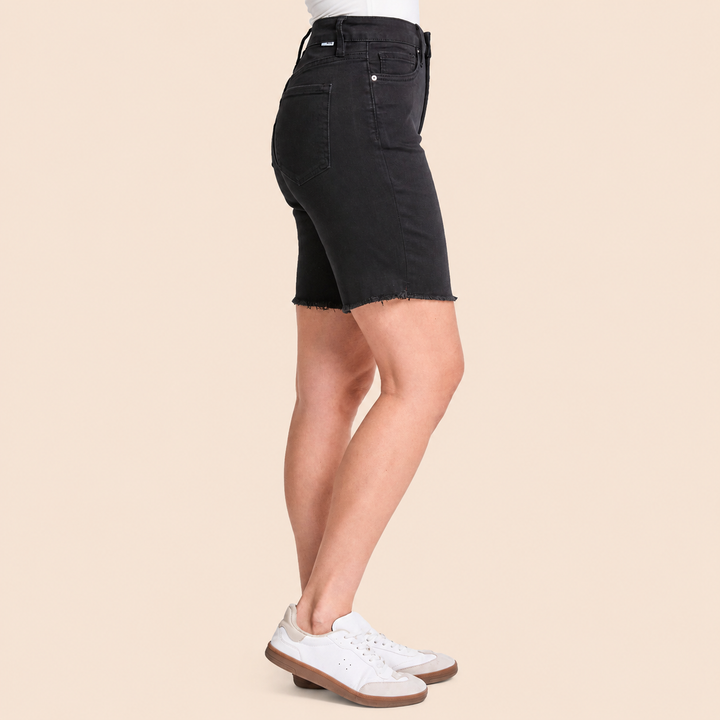 Black denim skirt worn by a person on a beige background