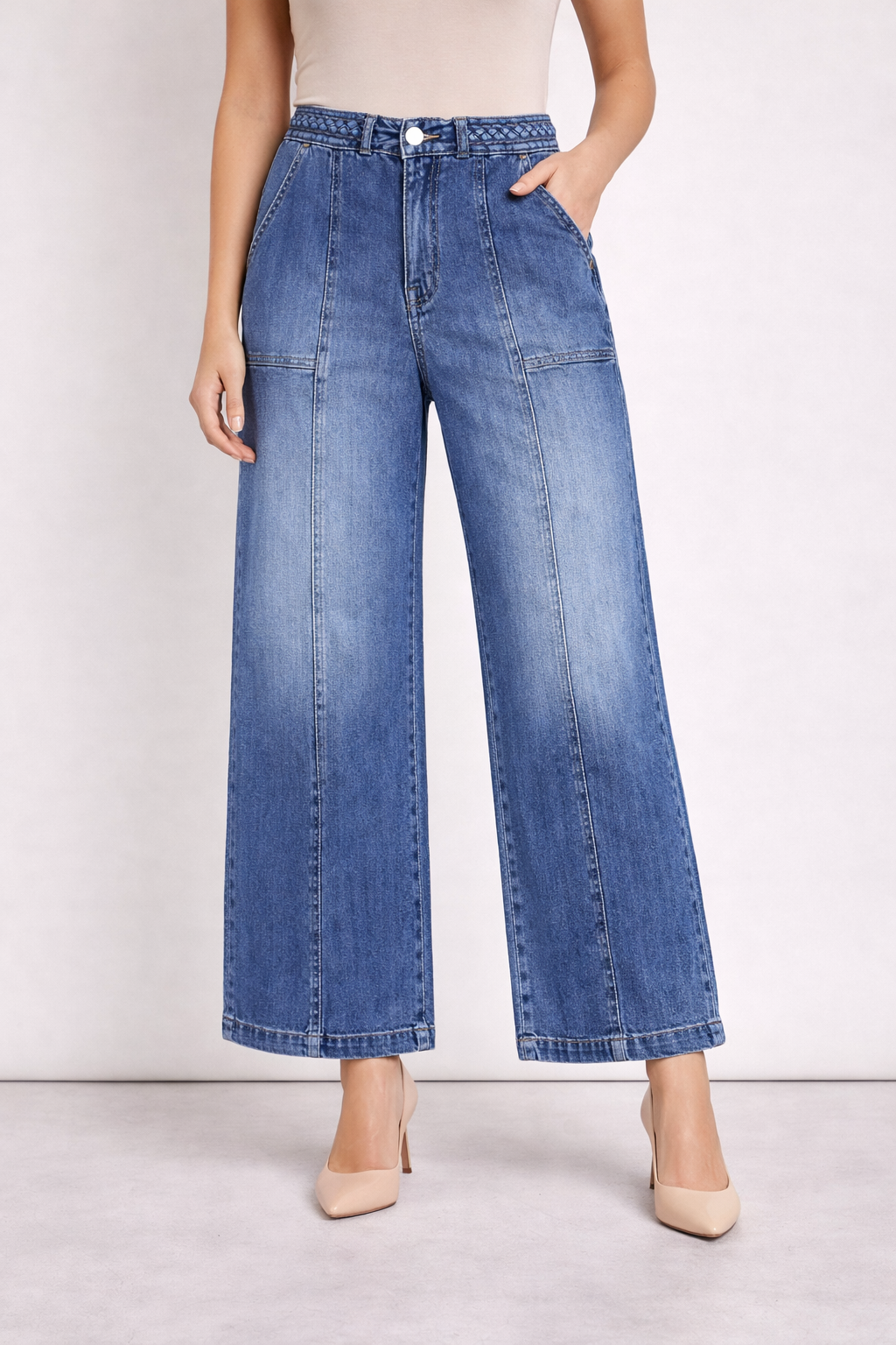 Person wearing blue wide-leg jeans on a plain background