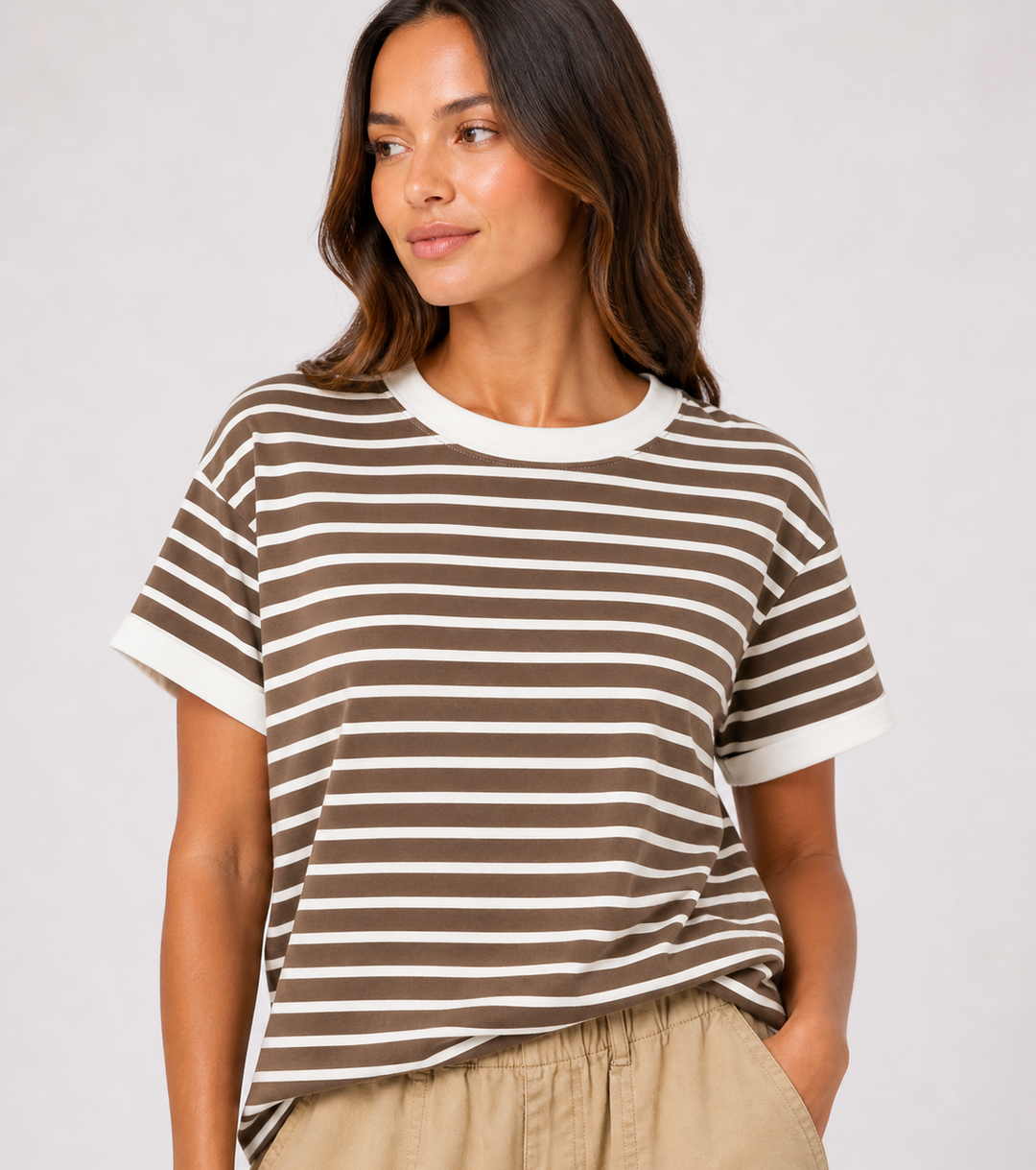 Woman wearing a brown and white striped t-shirt against a plain background
