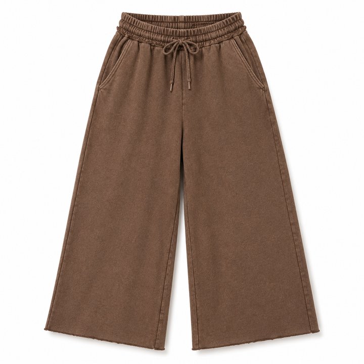 A pair of wide-leg cropped pants in a medium brown color, featuring an elastic waistband with a drawstring and side pockets, shown against a plain white background.