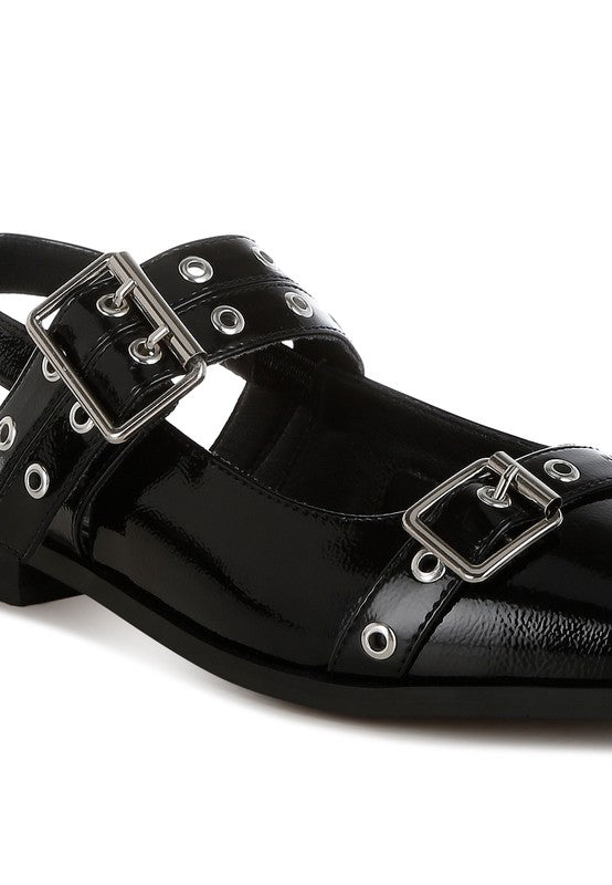 Black patent leather sandal with silver buckles on a white background