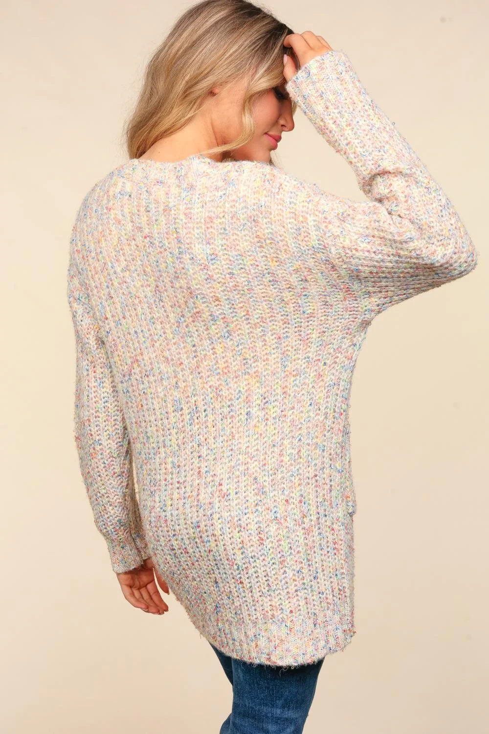 Woman wearing a multicolored cardigan against a beige background