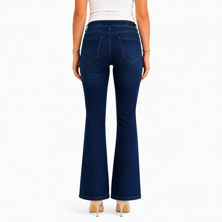 A model shown from the back wearing dark blue flare jeans, a white top, and beige heels against a plain white background.