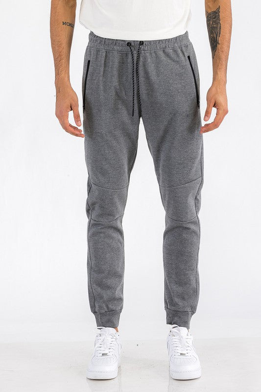 Person wearing gray jogger pants on a white background