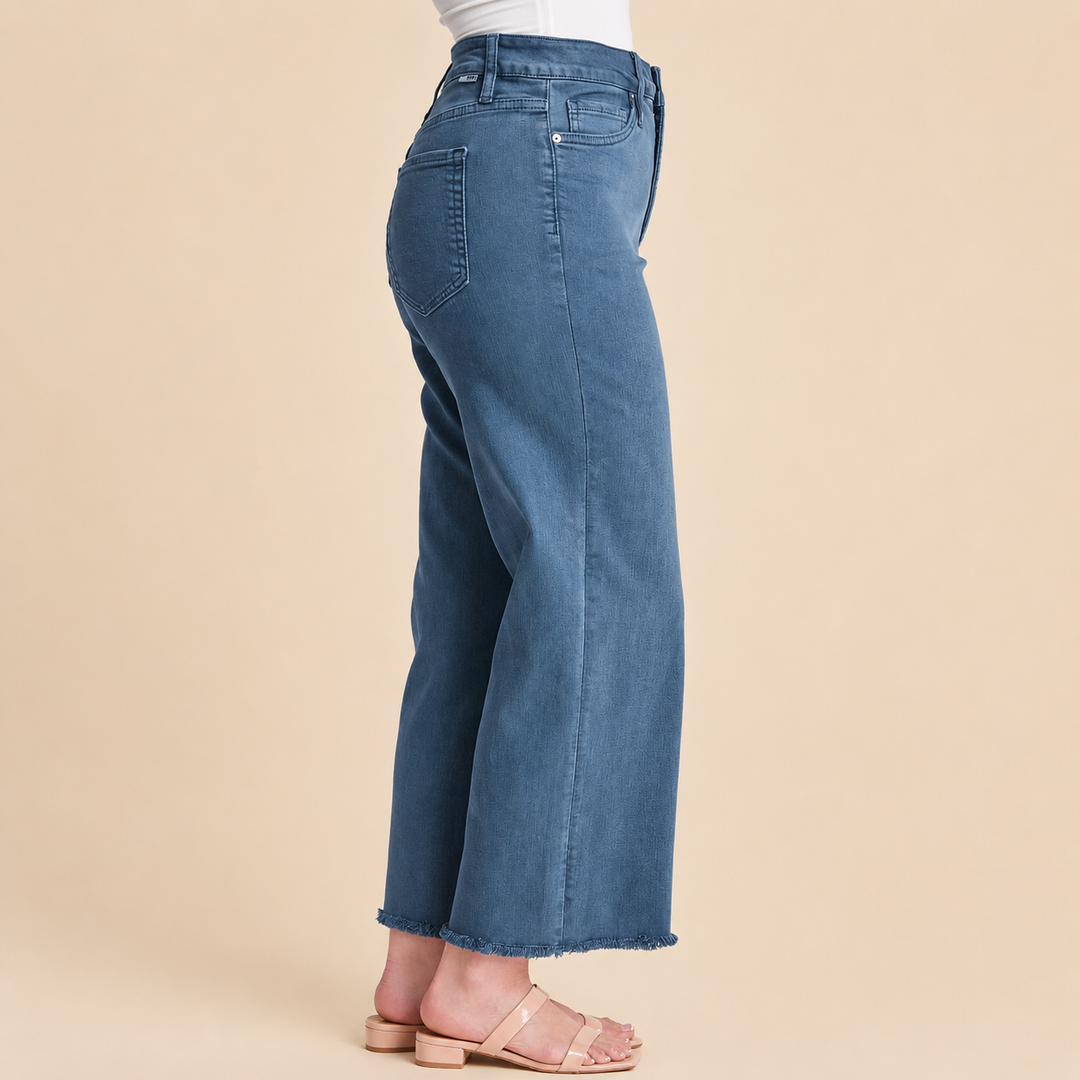 Blue jeans worn by a person on a beige background