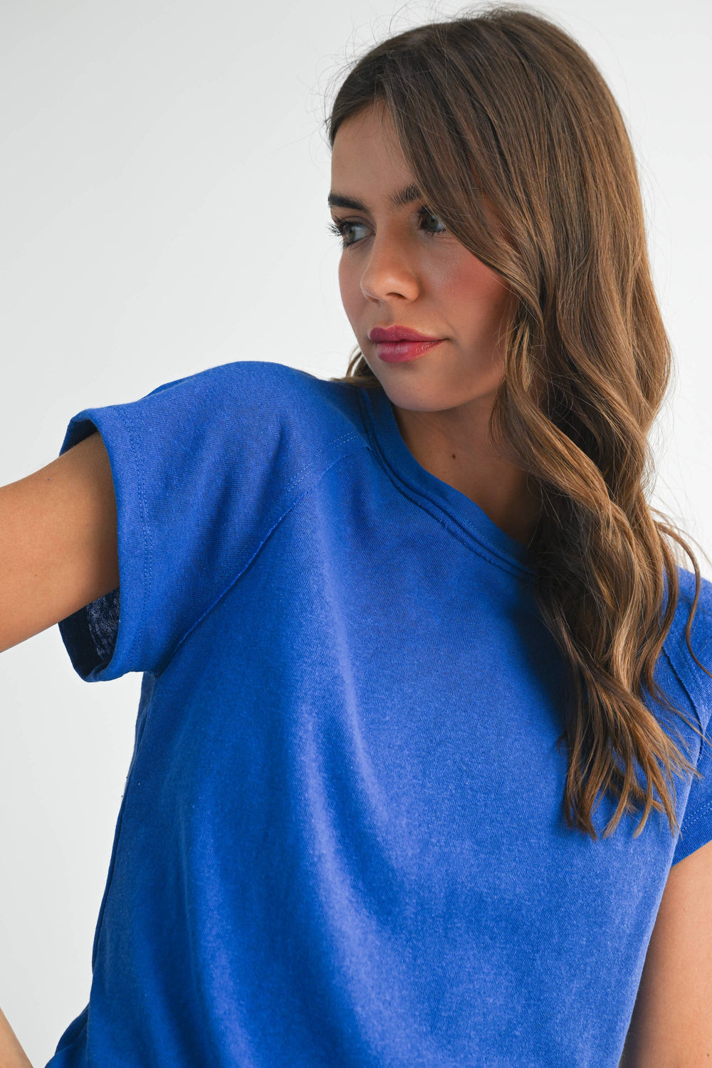 Woman wearing a blue top against a white background