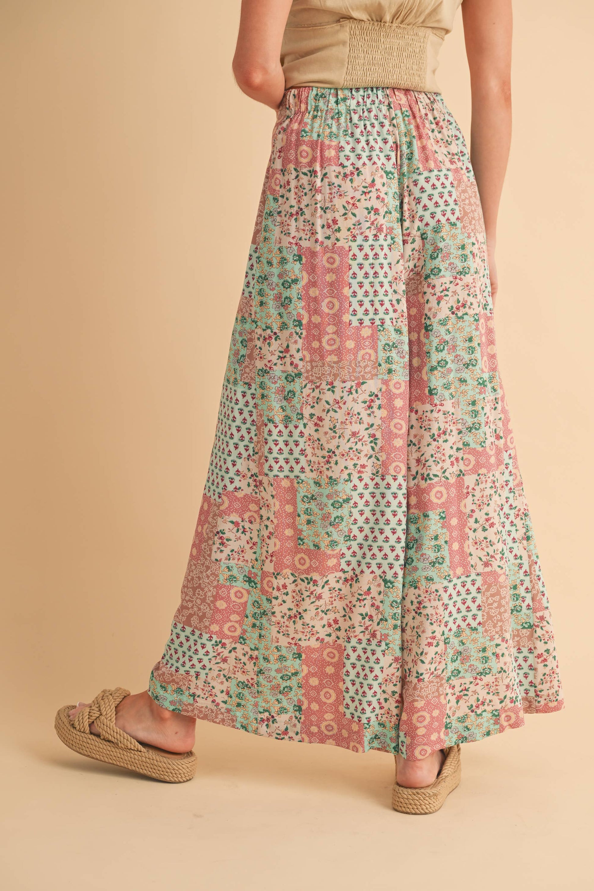 Person wearing a long, patterned pant on a beige background
