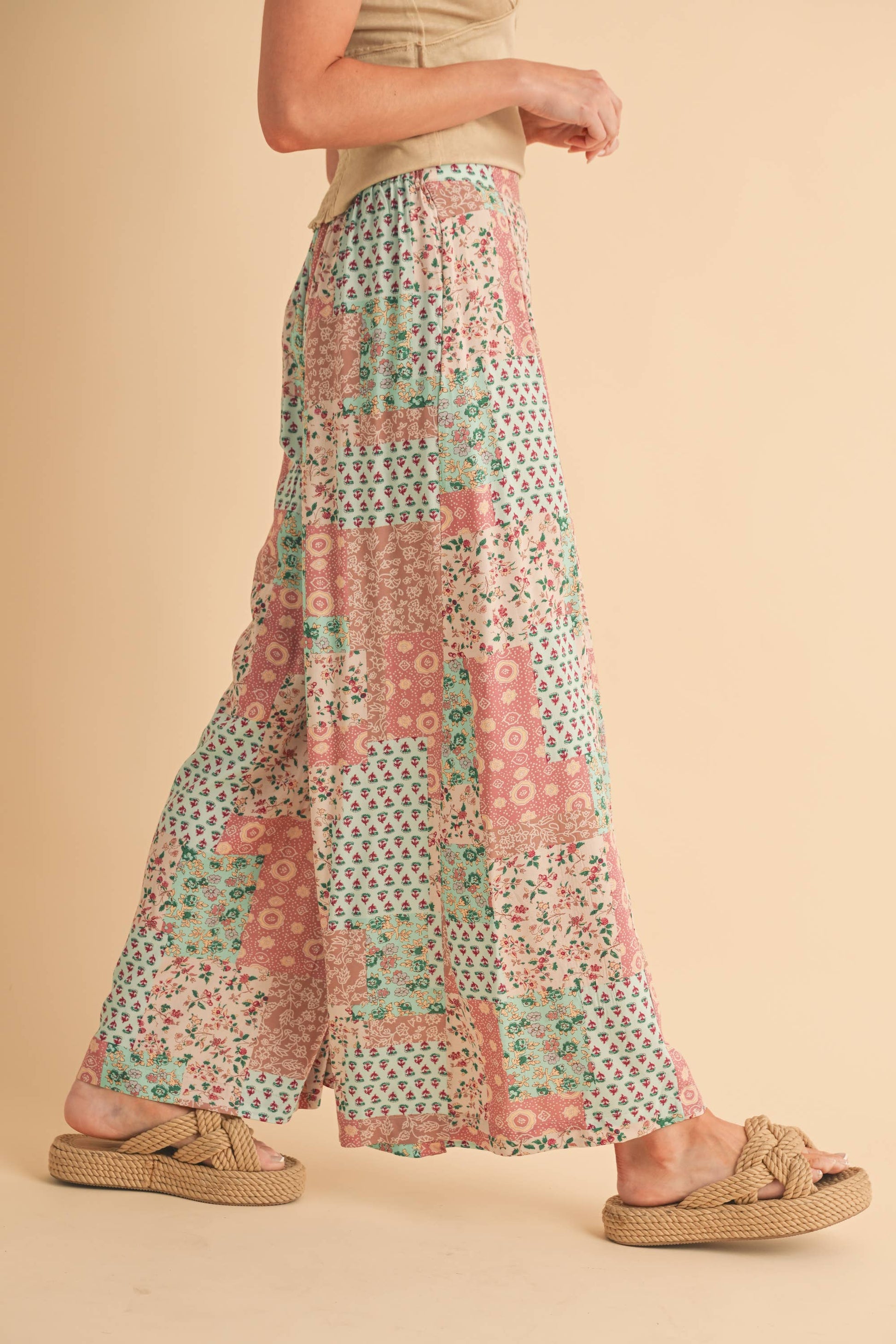 Person wearing a patterned pant on a beige background