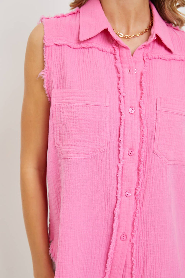 Close-up of a pink sleeveless button-up shirt with a neutral background