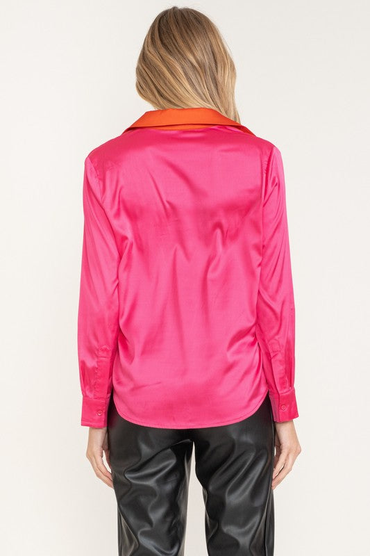 Person wearing a bright pink jacket with an orange collar on a white background