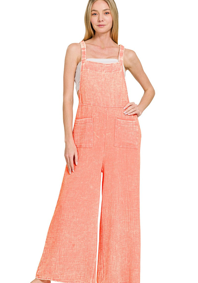 Woman wearing a coral checkered jumpsuit on a white background