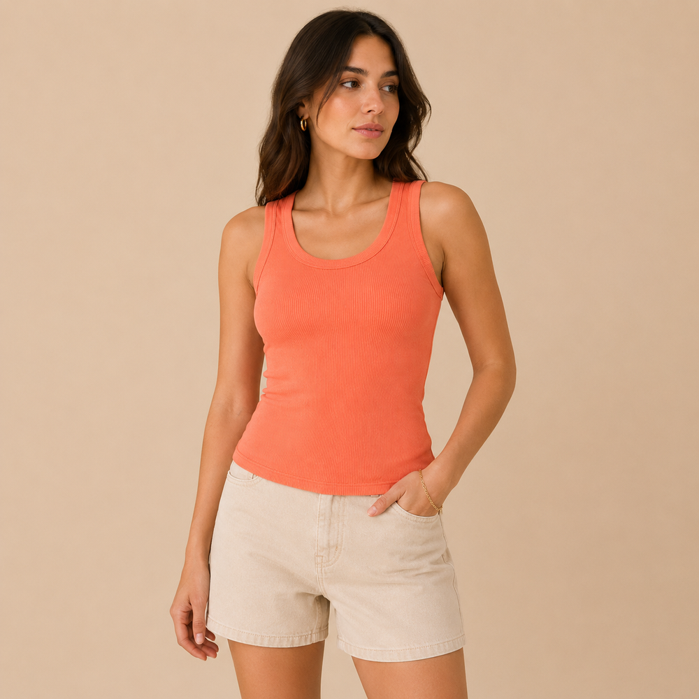Woman wearing a coral tank top and beige shorts against a beige background