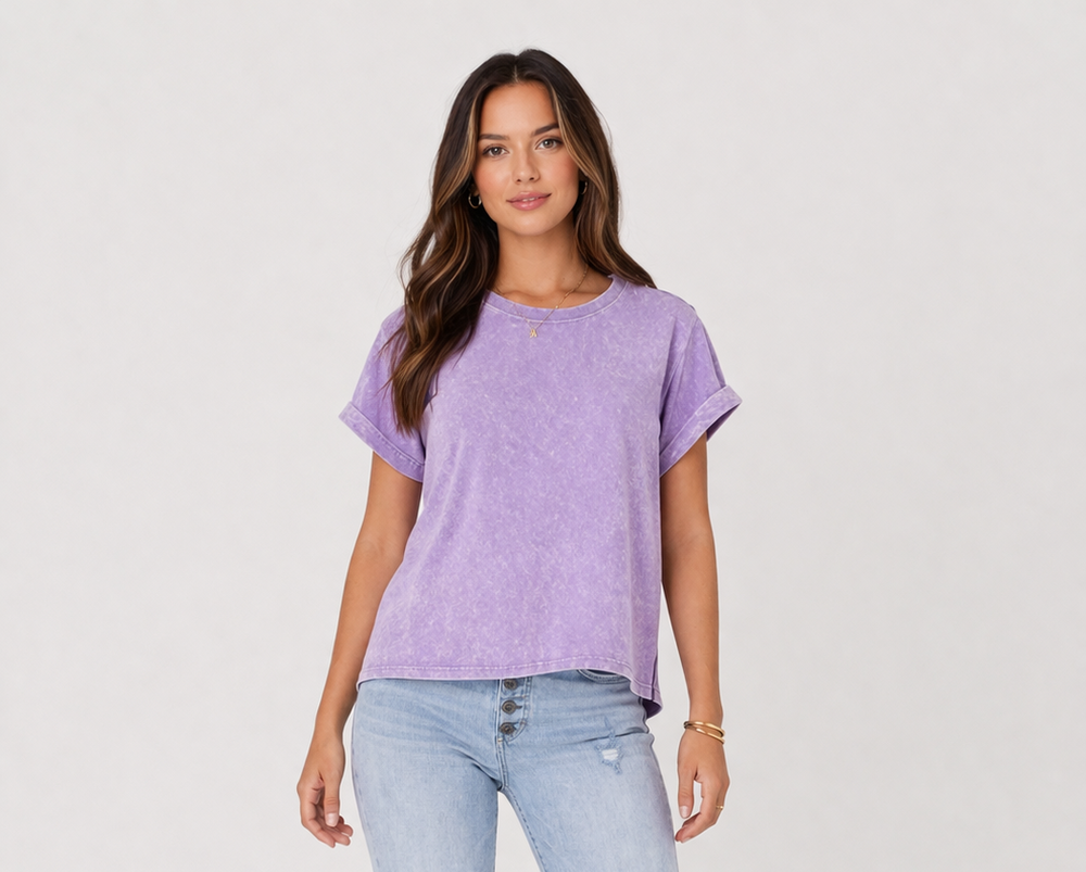Woman wearing a purple t-shirt and light blue jeans on a white background