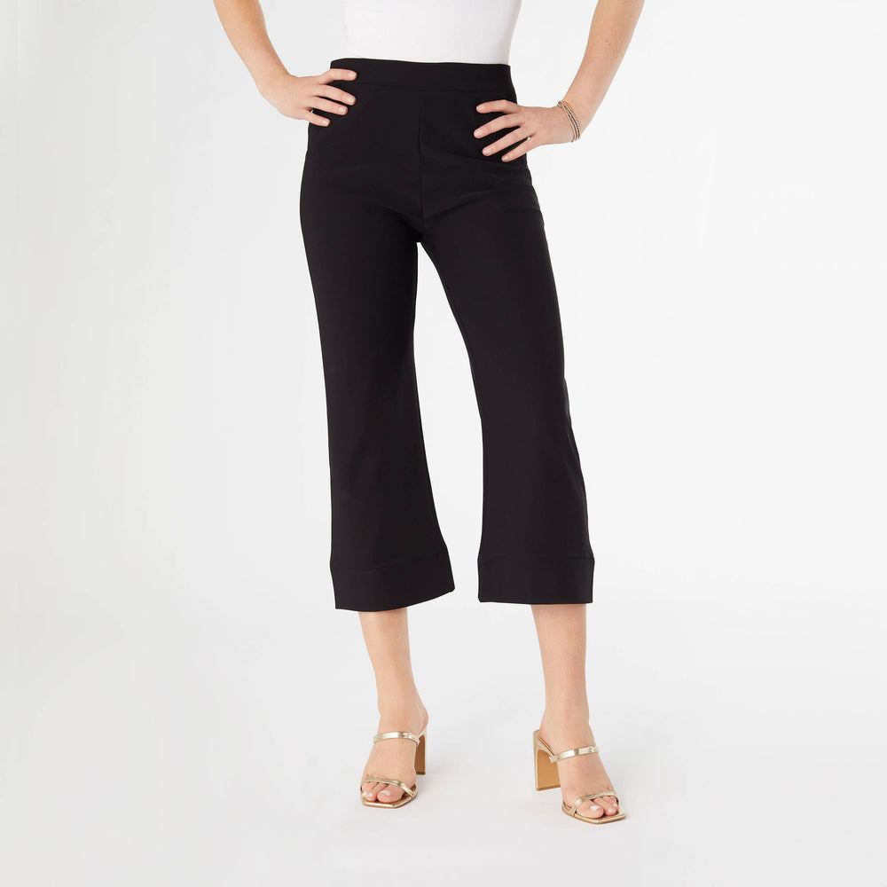 Person wearing black capri pants on a white background