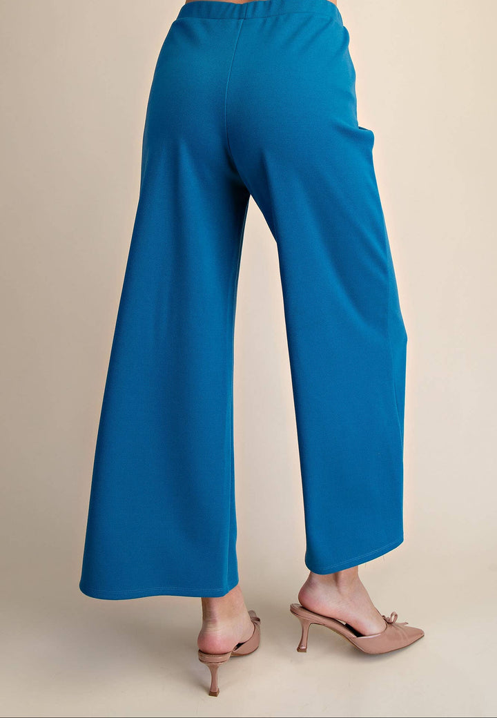 Blue pants worn by a person on a beige background