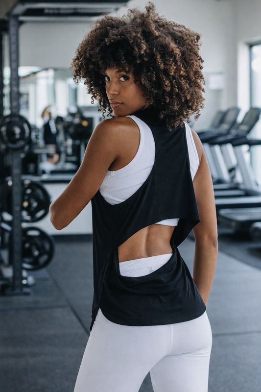 Person wearing a black and white athletic outfit in a gym setting