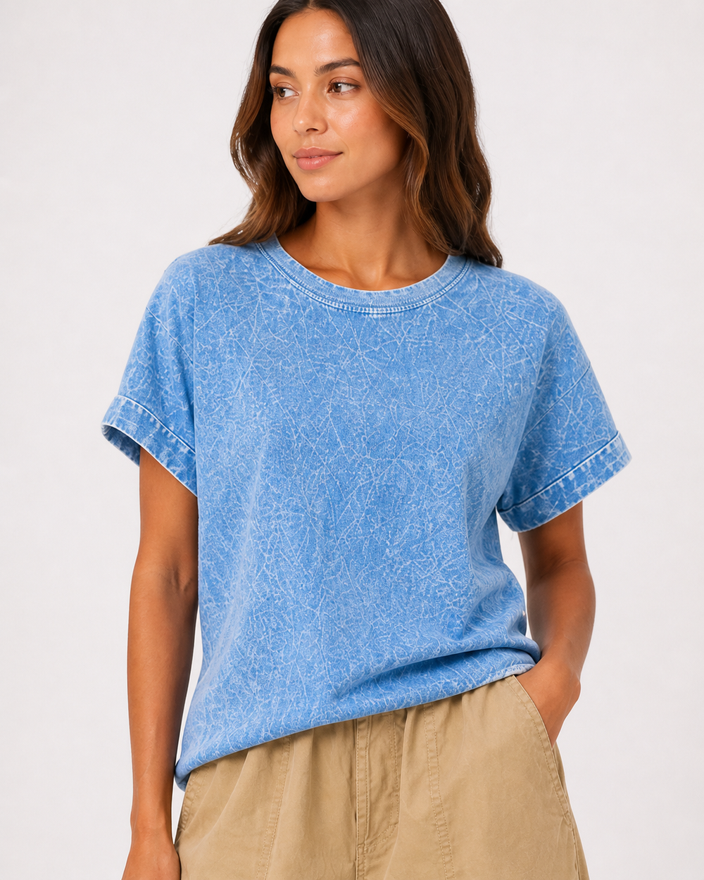 Woman wearing a blue t-shirt and beige pants on a white background