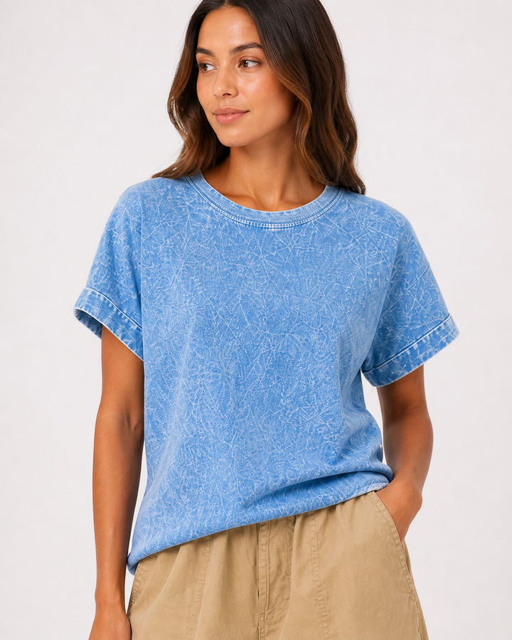 Woman wearing a blue t-shirt and beige pants on a white background
