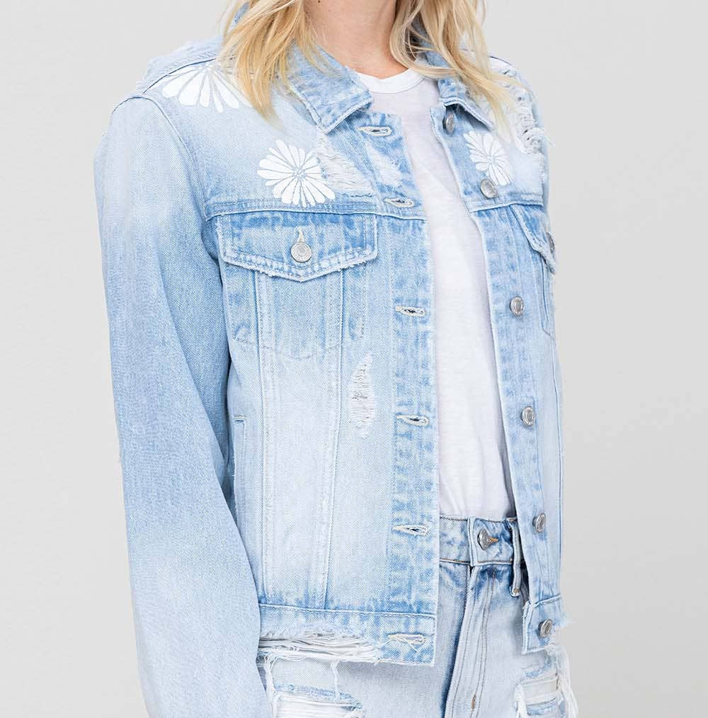 Person wearing a light blue denim jacket and shorts on a plain background