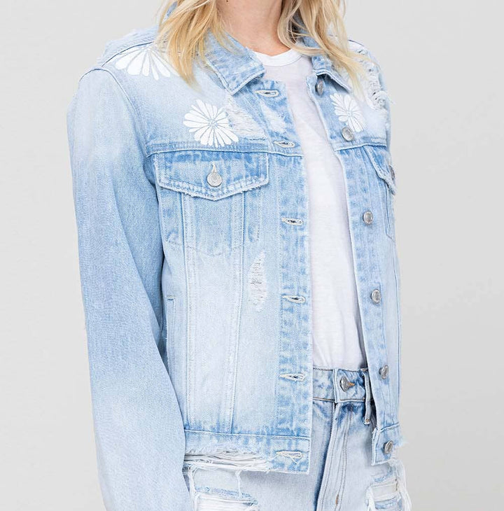 Person wearing a light blue denim jacket and shorts on a plain background